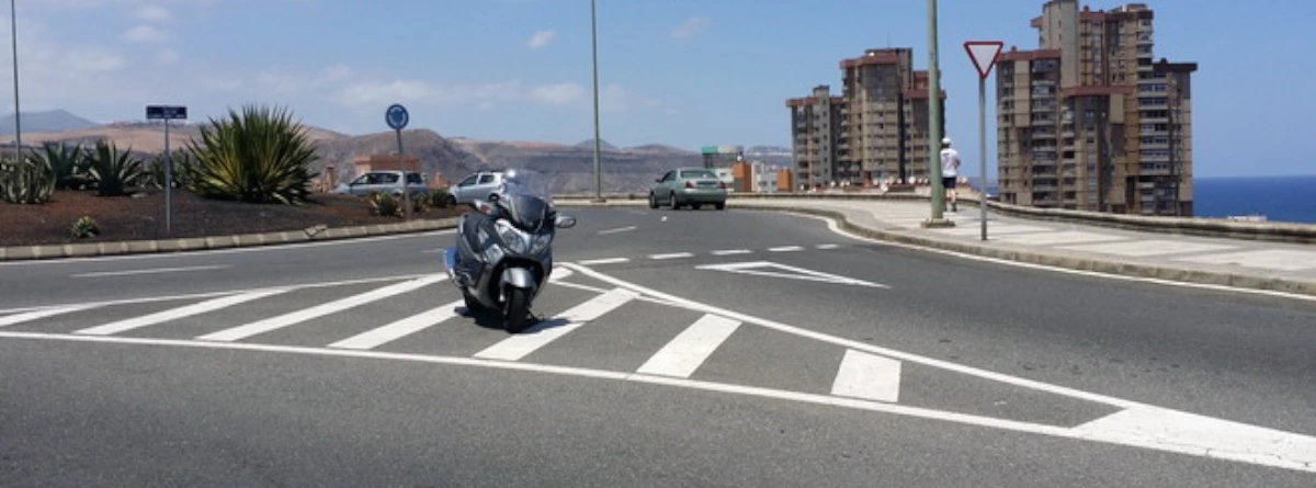  Isleta en la carretera de tipo cebreado en una bifurcación con motocicleta en el carril
